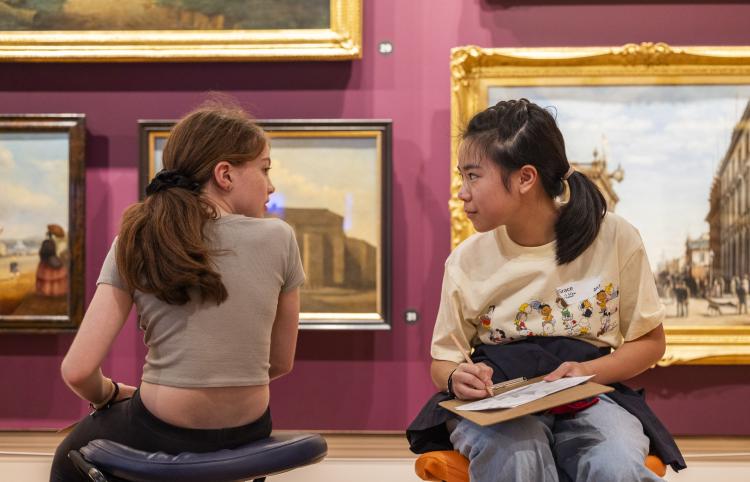 two little girls talking with drawing boards in paintings gallery red room