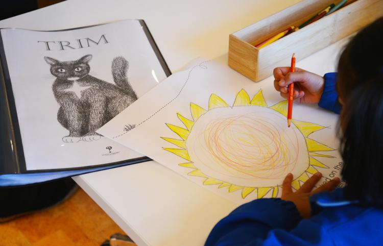 A student drawing a picture of the sun