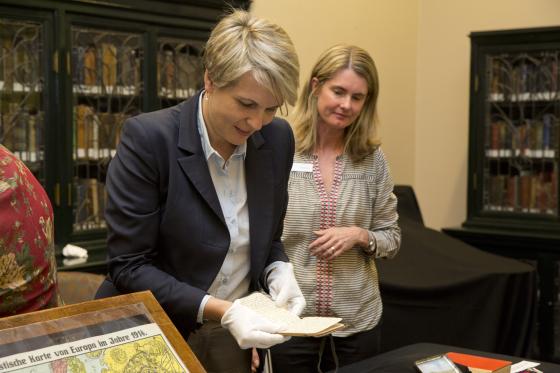 Woman looking at old diaries with gloves on