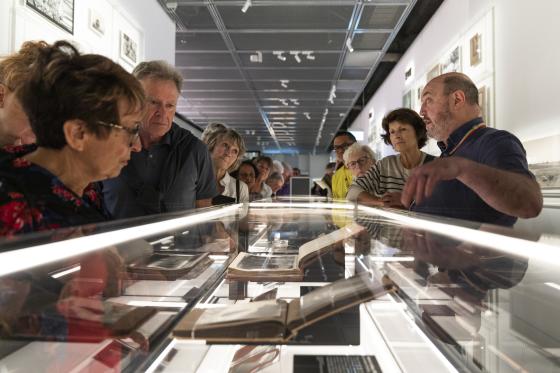 Tour guide showing objects in a glass box
