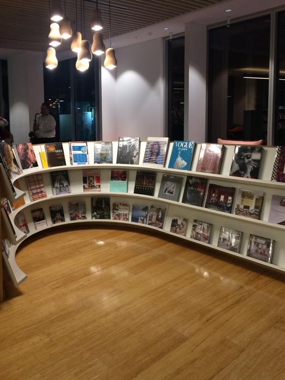 Books displayed on a curved shelf.