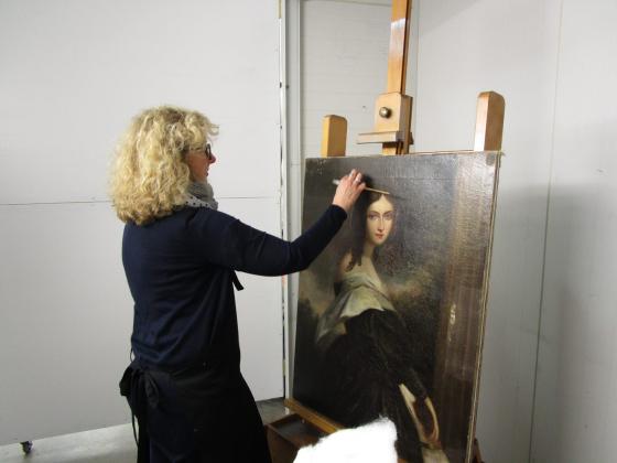 Julia Sharp, Conservation Manager, David Stein & Co, works on the painting 
